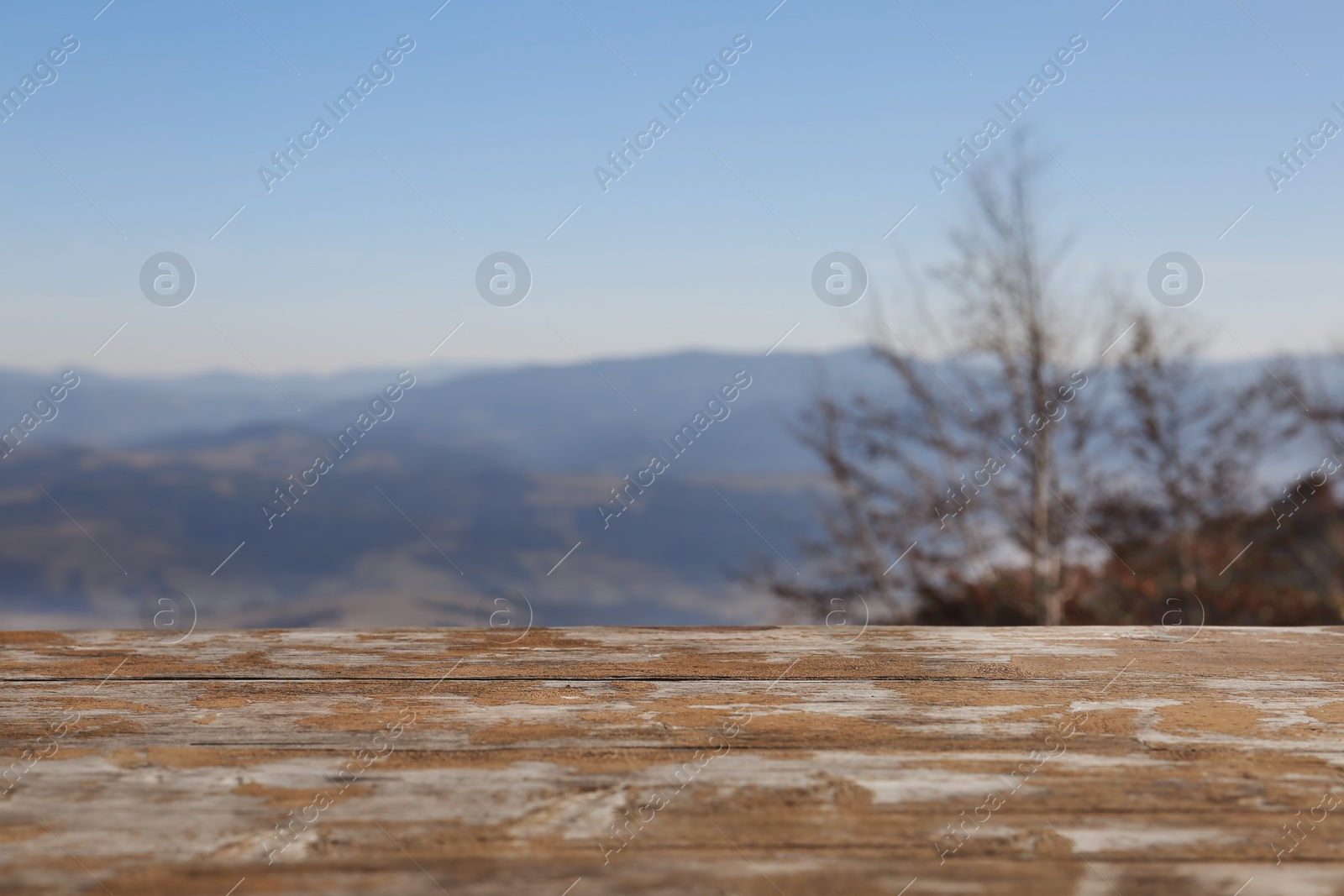 Photo of Empty wooden desk against mountain landscape and sky