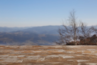 Photo of Empty wooden desk against mountain landscape and sky
