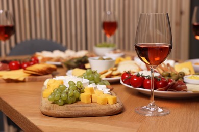 Rose wine and appetizers served on wooden table indoors, space for text