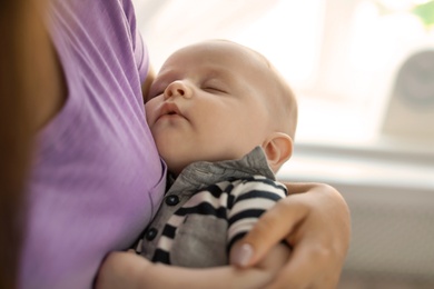 Photo of Mother with her sleeping baby at home, closeup view