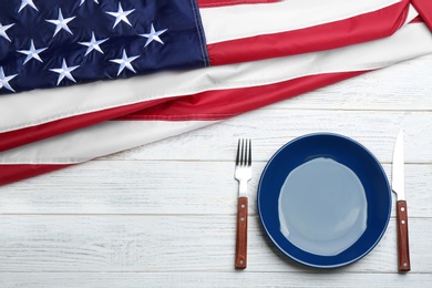 Photo of Patriotic table setting with USA flag on wooden background, flat lay. Space for text