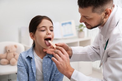 Pediatrician examining little girl in office at hospital