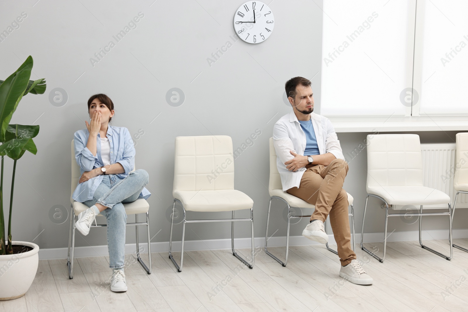 Photo of Man and woman waiting for appointment indoors