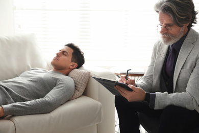 Photo of Psychotherapist and patient in office. Hypnotherapy session