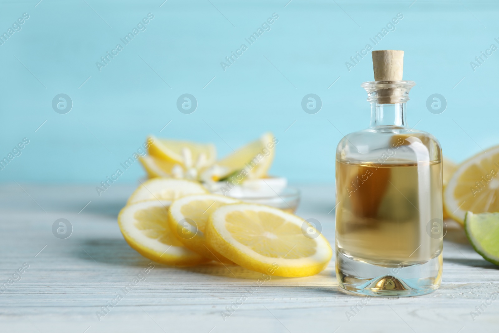 Photo of Citrus essential oil on white wooden table. Space for text