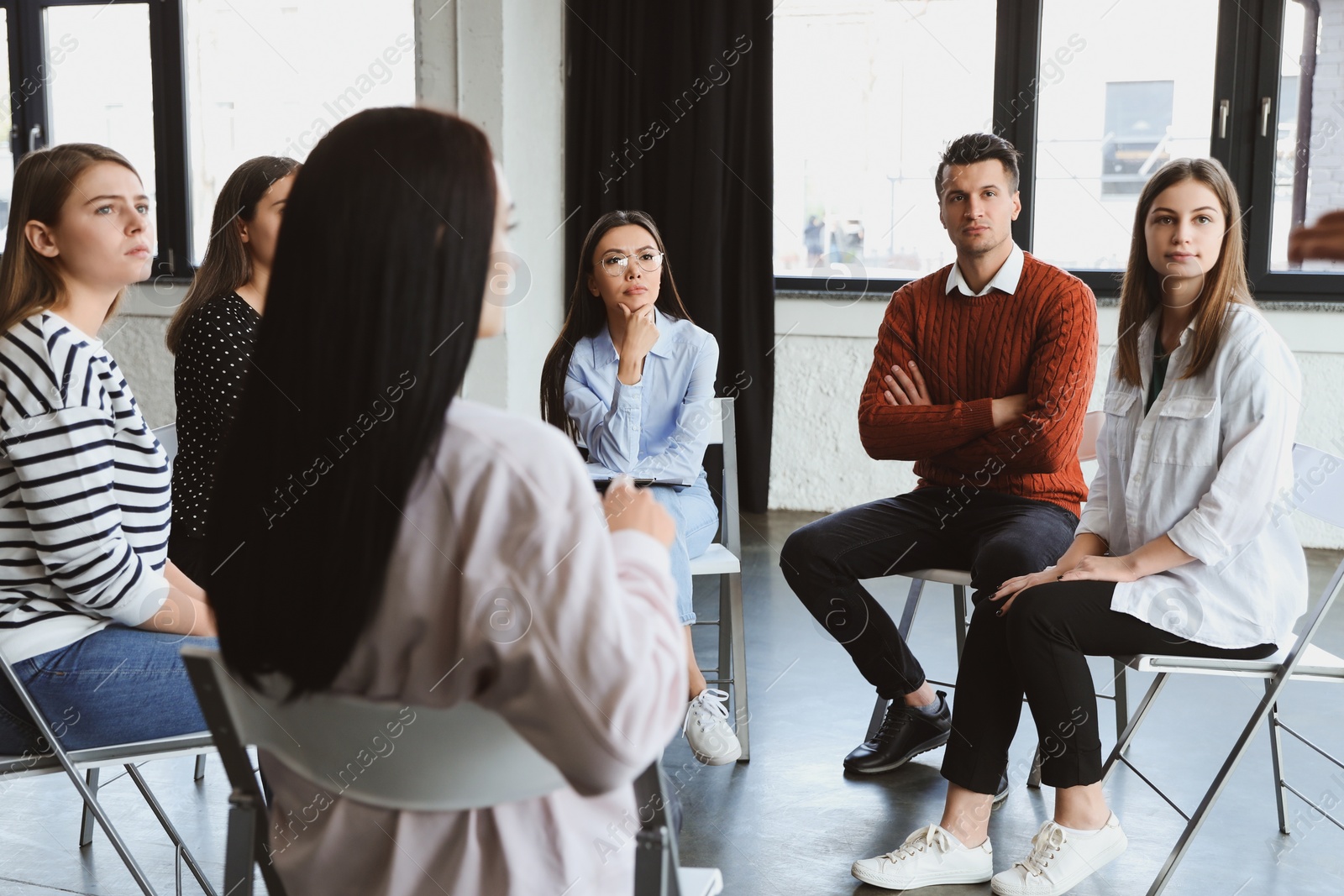 Photo of Psychotherapist working with patients in group therapy session indoors