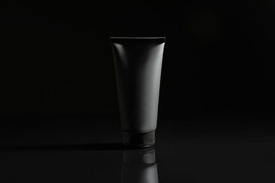 Photo of Tube of men's facial cream on black background