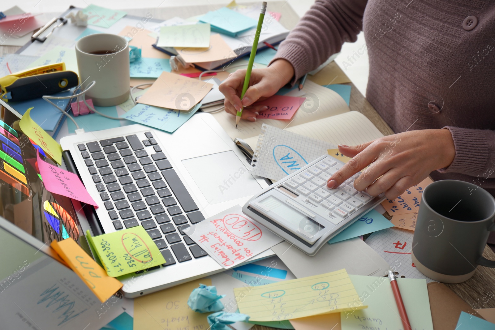 Photo of Overwhelmed woman working at messy office desk, closeup