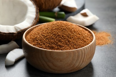 Photo of Natural coconut sugar in wooden bowl on grey table