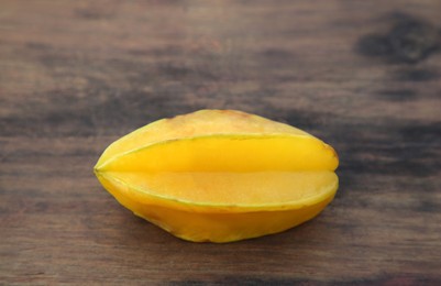 Photo of One delicious ripe carambola on wooden table