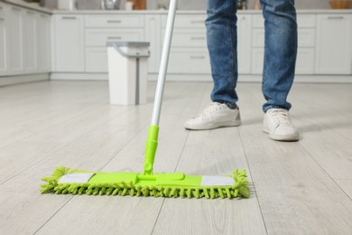 Man cleaning floor with mop indoors, closeup