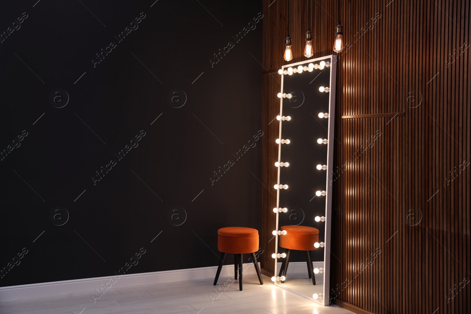 Image of Full length dressing mirror with lamps and stool in stylish room interior. Space for text