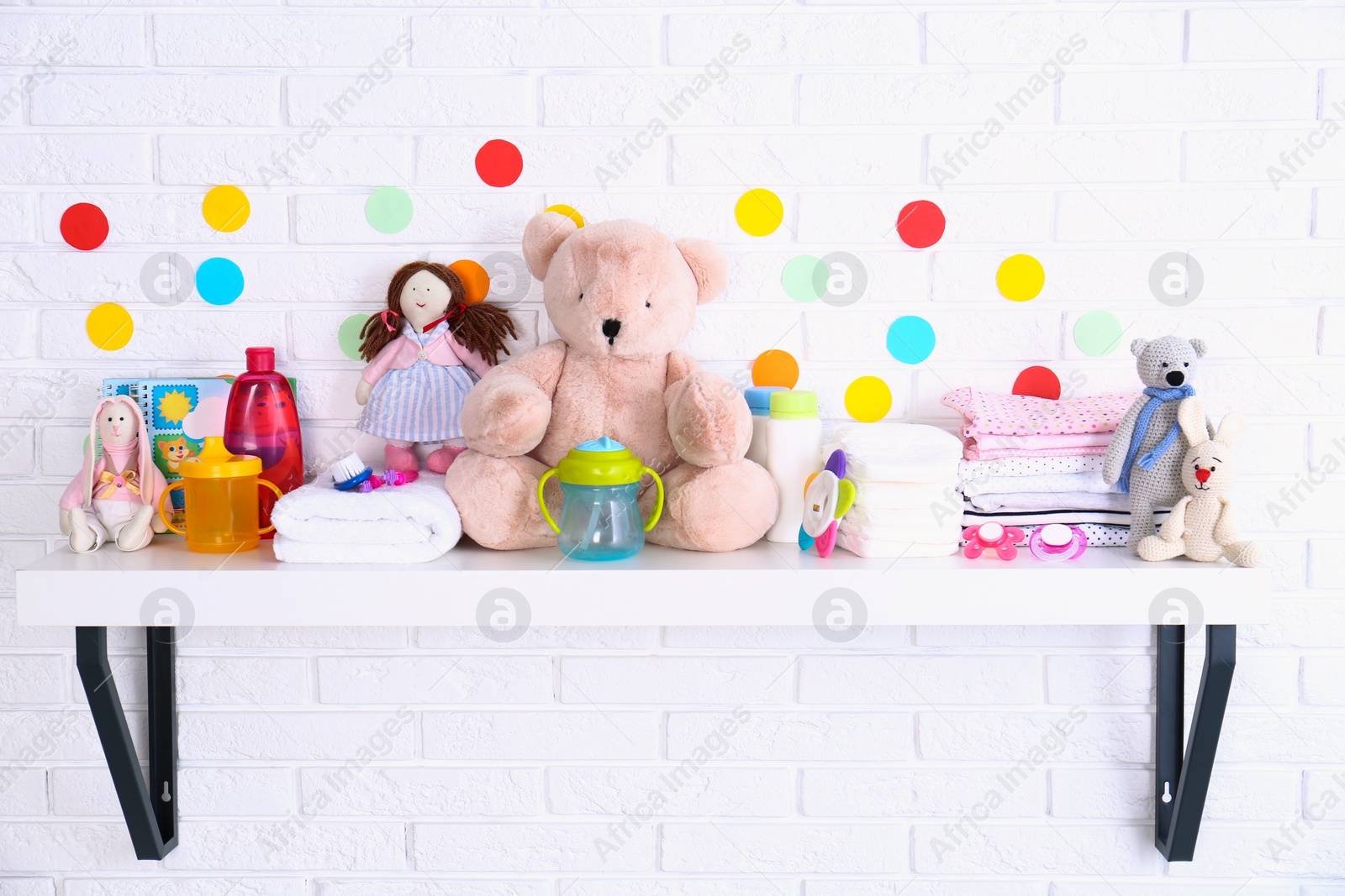 Photo of Baby accessories on shelf near white brick wall