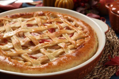 Delicious homemade apple pie and autumn decor on table, closeup