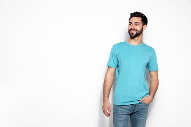 Young man in t-shirt on light background. Mock up for design