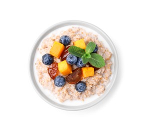 Photo of Tasty wheat porridge with milk, pumpkin, dates and blueberries in bowl isolated on white, top view