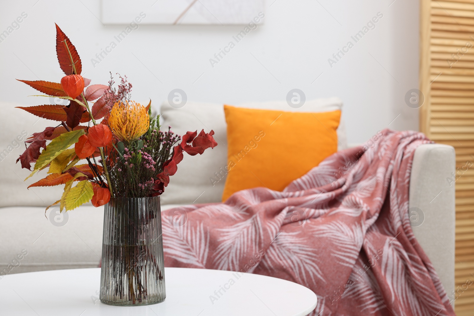 Photo of Vase with bouquet of dry flowers and leaves on side table in living room, space for text