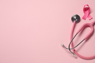 Photo of Breast cancer awareness. Pink ribbon and stethoscope on color background, flat lay. Space for text