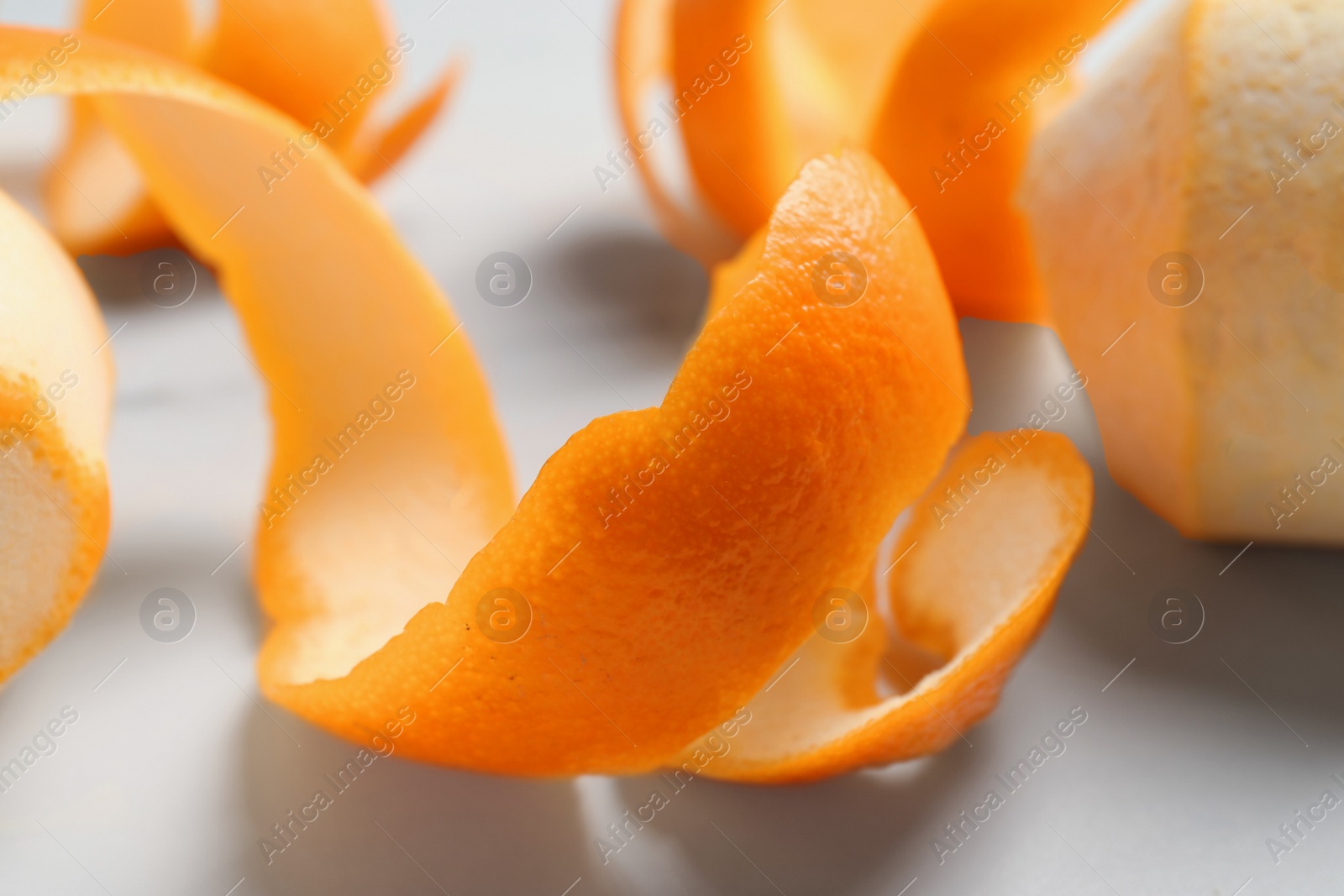 Photo of Peeled fresh oranges with zest preparing for drying on white table, closeup