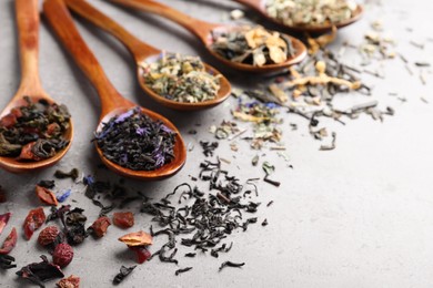 Photo of Composition with different teas and spoons on light grey stone table. Space for text