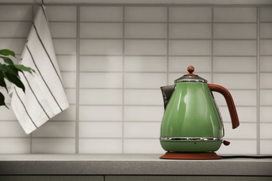 Photo of Modern electric kettle on grey kitchen counter. Space for text