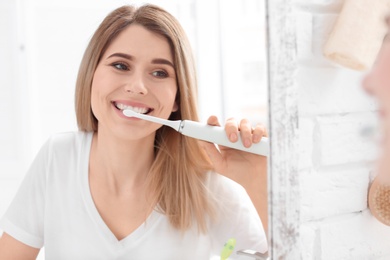 Young woman brushing her teeth in bathroom