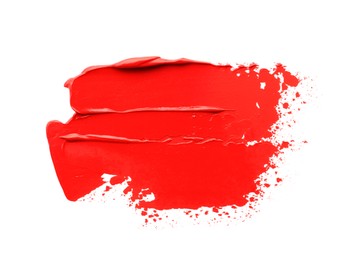 Photo of Red oil paint stroke on white background, top view