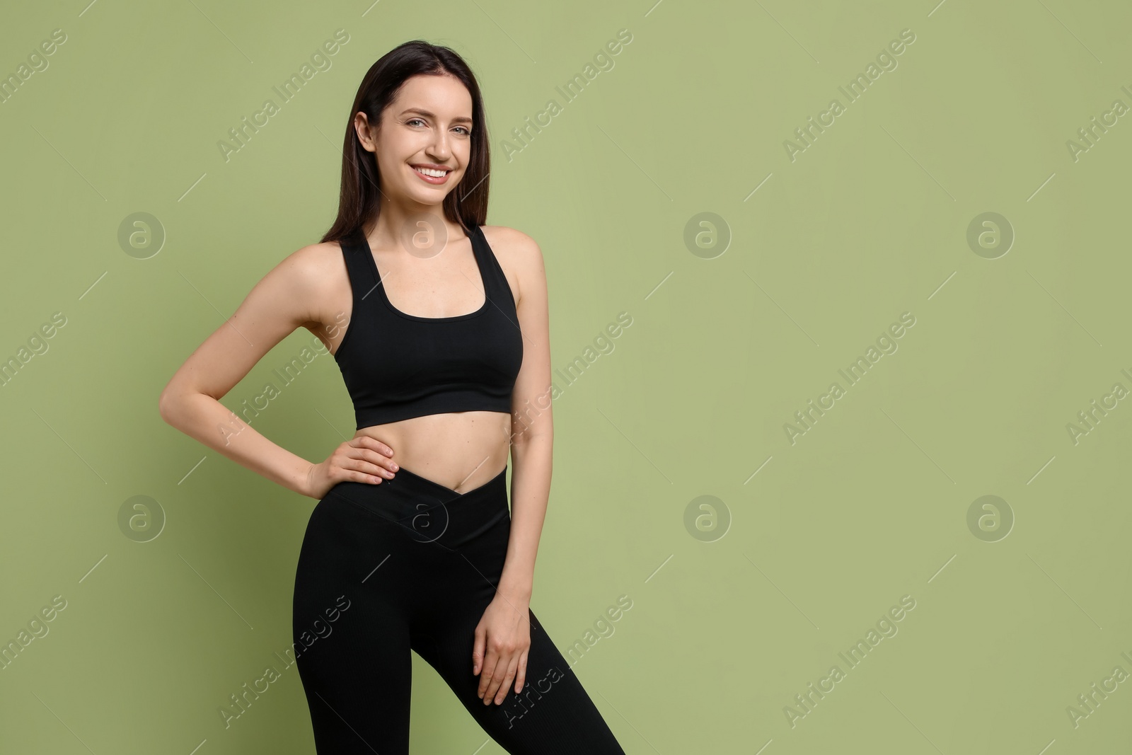 Photo of Happy young woman with slim body on green background, space for text