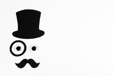 Photo of Man's face made of fake mustache, hat, eyes and monocle on white background, top view. Space for text