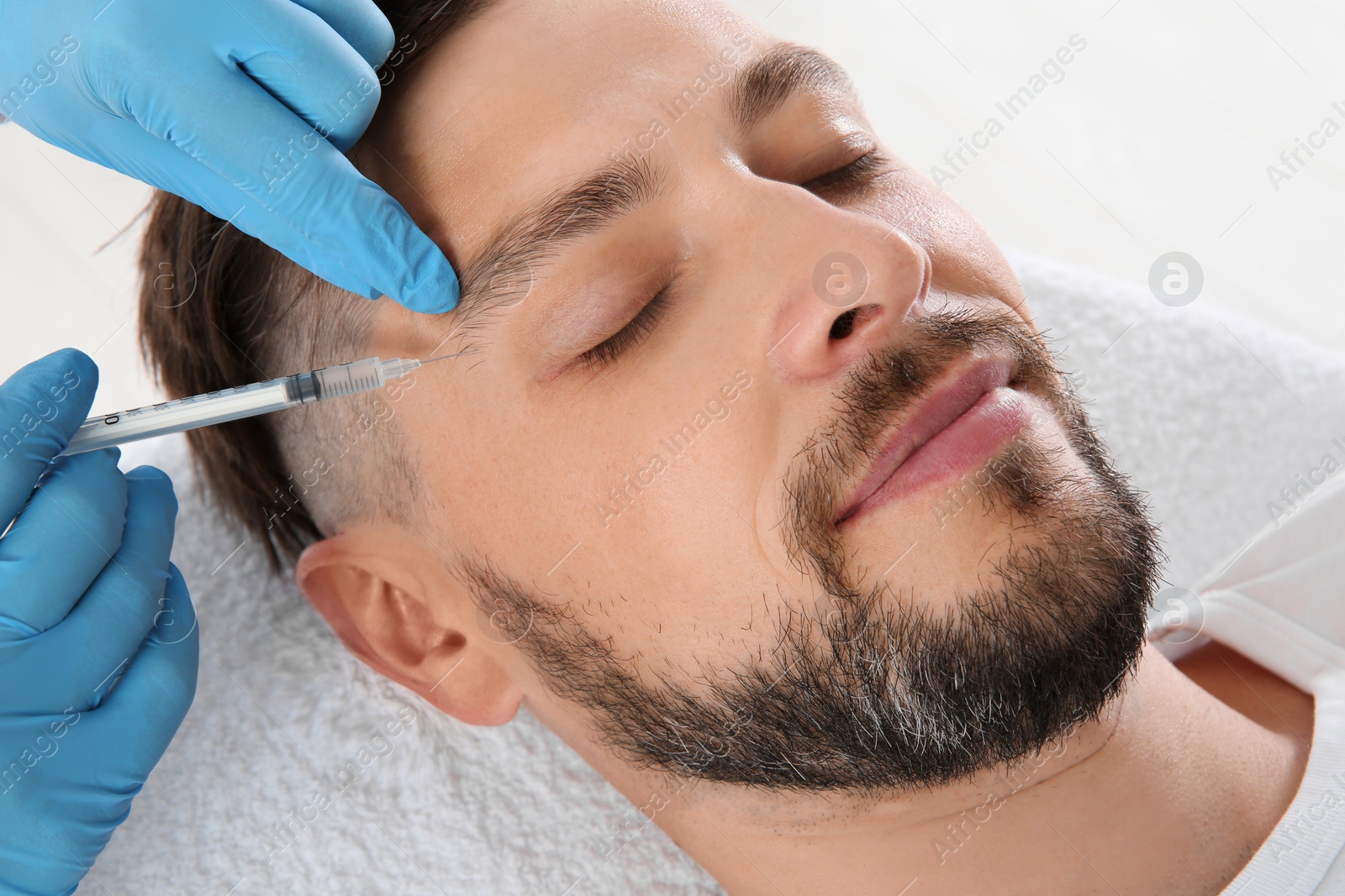 Photo of Man getting facial injection in clinic. Cosmetic surgery concept