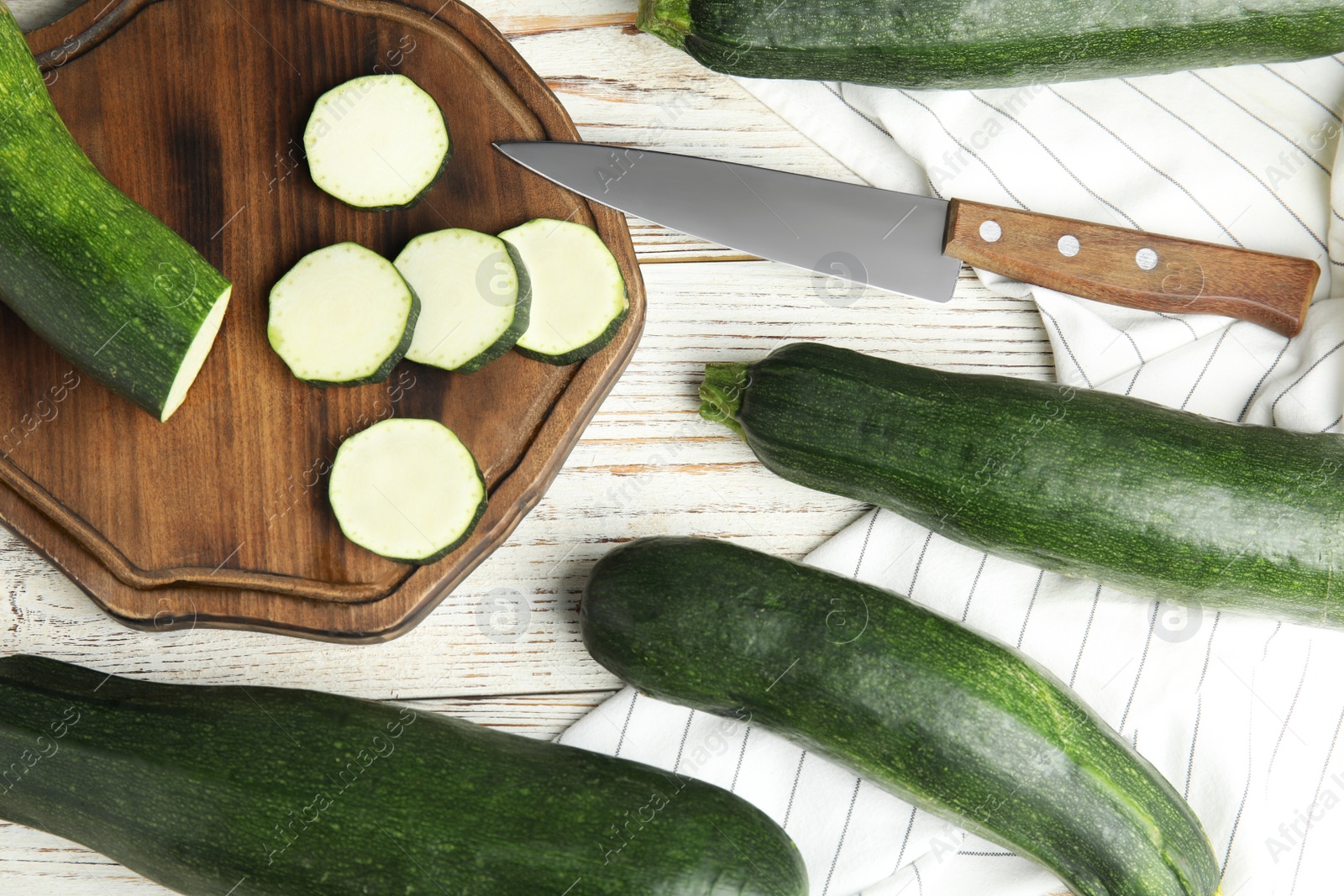 Photo of Flat lay composition with fresh ripe green zucchinis on white wooden table