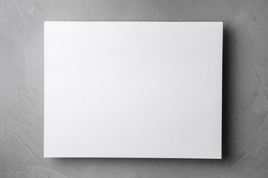 Blank paper sheets on light grey stone background, top view. Mock up for design