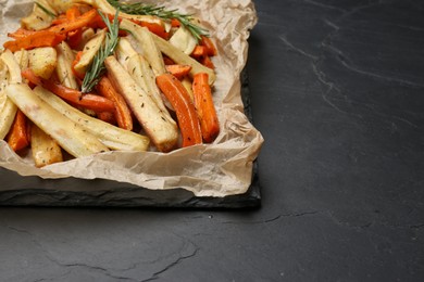 Parchment with tasty baked parsnip and bell pepper on dark grey table, closeup. Space for text