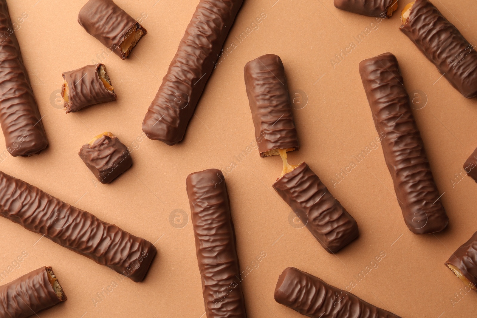 Photo of Sweet tasty chocolate bars on beige background, flat lay
