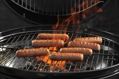 Photo of New modern barbecue grill with tasty sausages, closeup