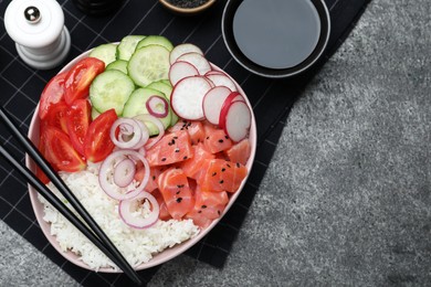 Delicious poke bowl with salmon and vegetables served on grey table, flat lay. Space for text