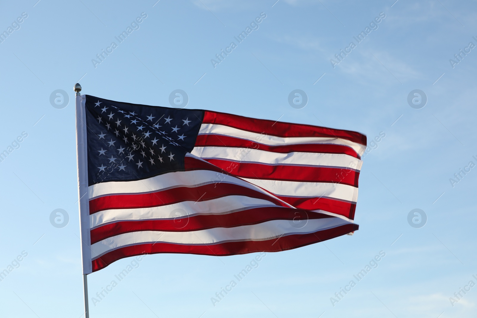 Photo of American flag fluttering outdoors on sunny day