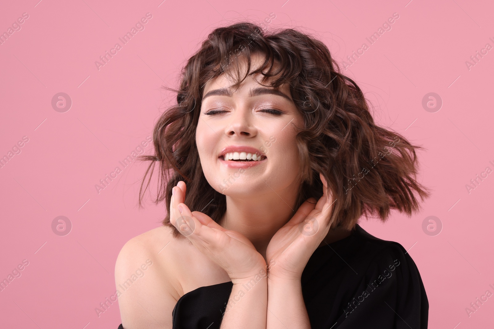 Photo of Portrait of beautiful young woman with wavy hairstyle on pink background