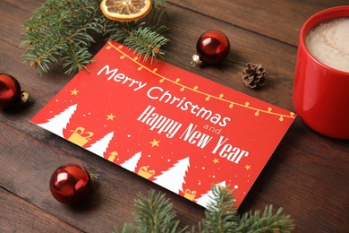 Photo of Greeting card, Christmas decor and cup of cocoa on wooden background, closeup