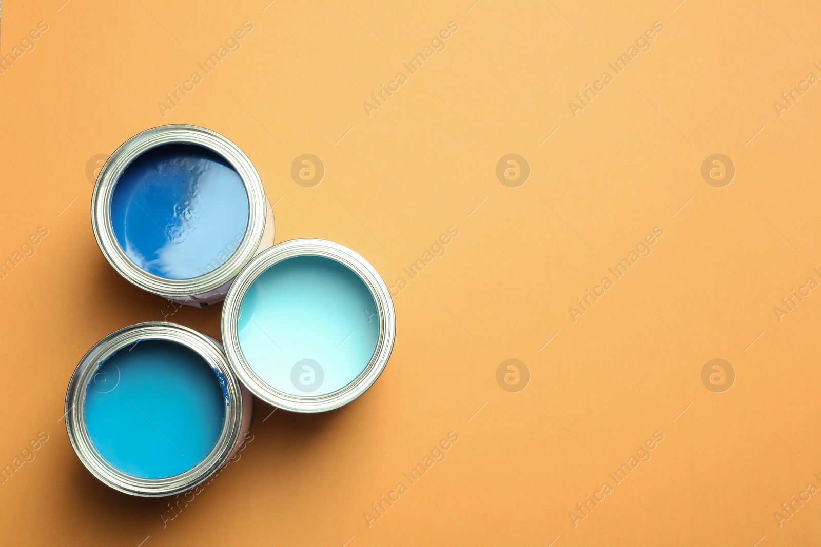 Photo of Flat lay composition with paint cans and space for text on color background