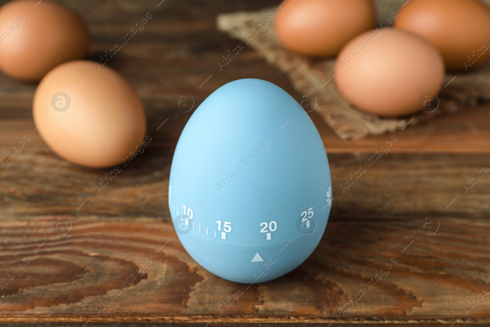 Photo of Kitchen timer and eggs on wooden table