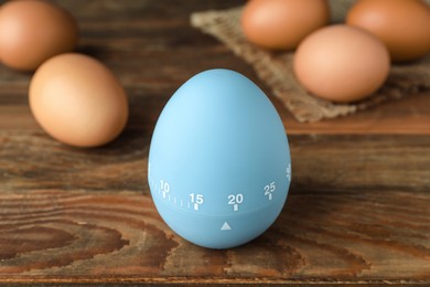 Kitchen timer and eggs on wooden table
