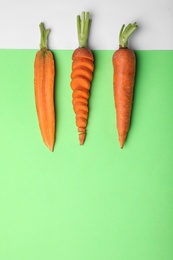 Photo of Flat lay composition with fresh carrots on color background. Space for text