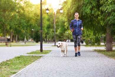 Young woman with her dog together in park. Pet care