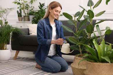 Photo of Woman watering beautiful potted houseplants at home