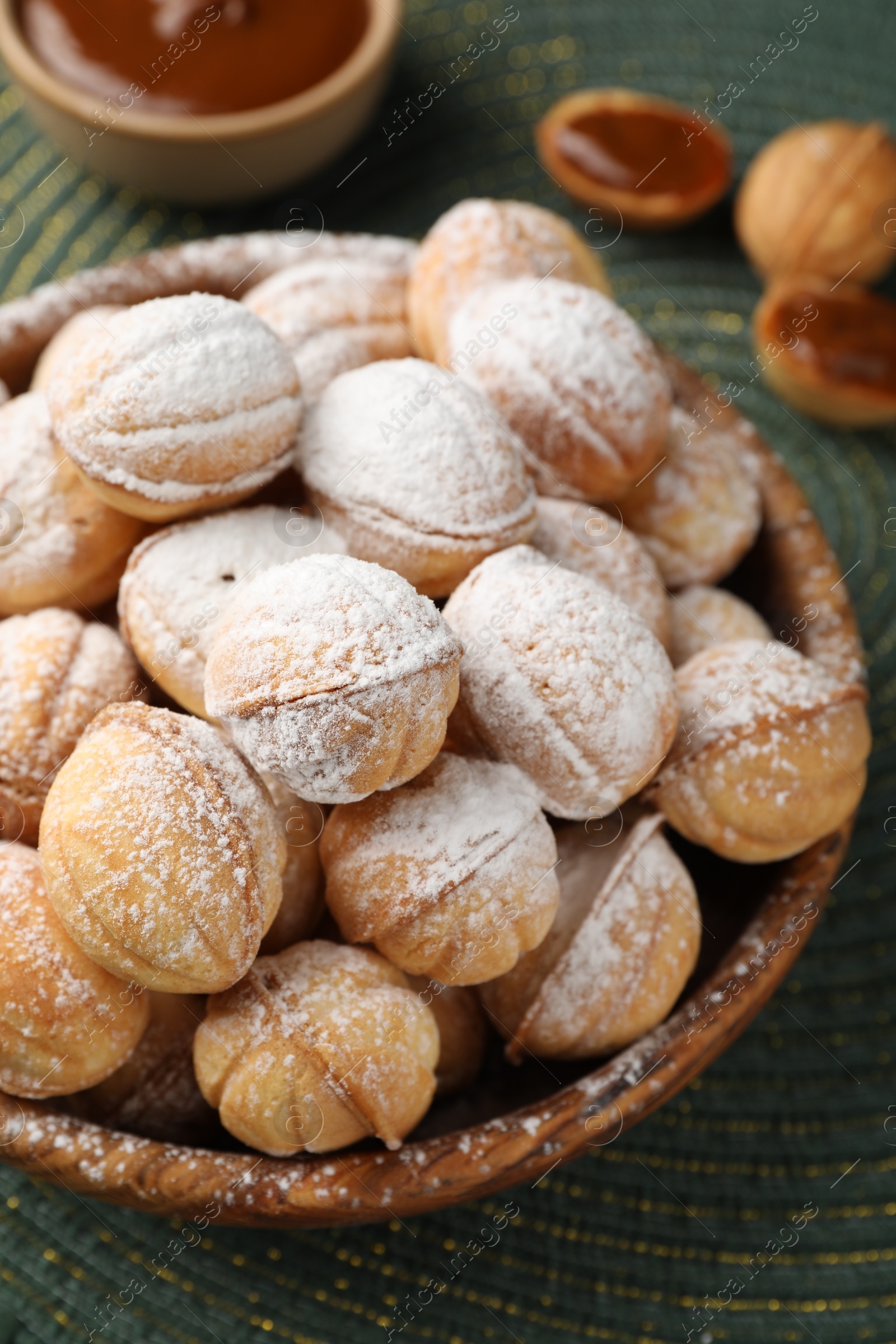 Photo of Bowl of delicious nut shaped cookies on table, closeup
