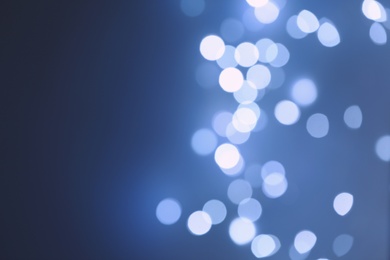 Blurred view of beautiful lights on blue background, space for text