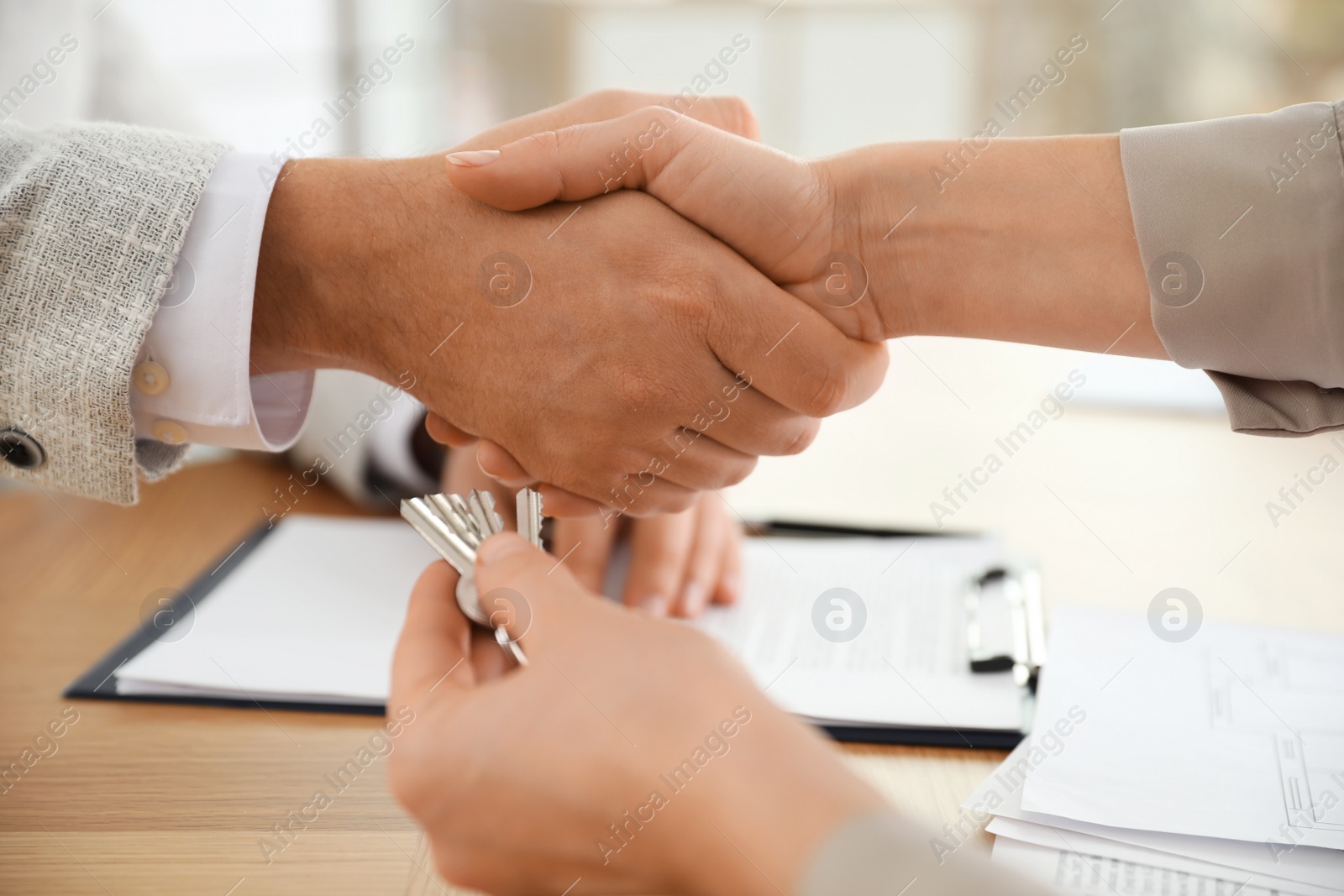 Photo of Real estate agent shaking hands with client in office, closeup