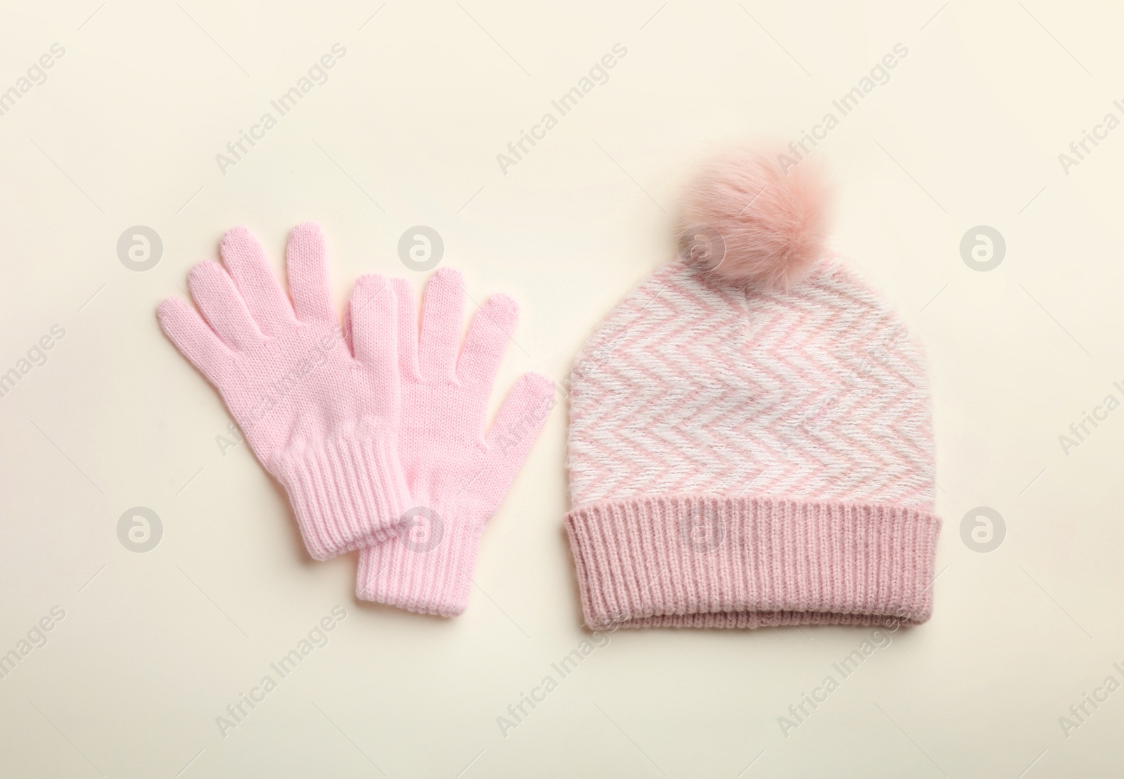 Photo of Woolen gloves and hat on beige background, flat lay