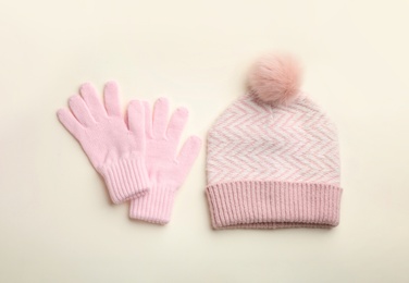 Photo of Woolen gloves and hat on beige background, flat lay